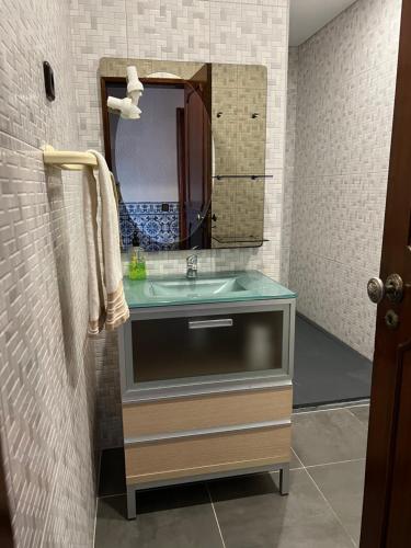 y baño con lavabo y espejo. en Alojamento das Laranjeiras, en Fernao Ferro