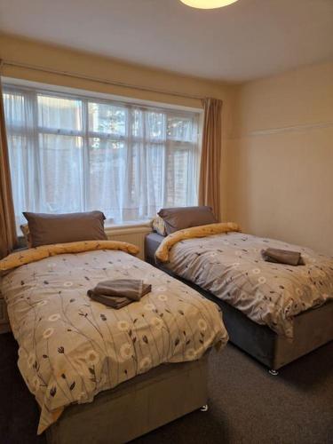 a bedroom with two beds and a window at Modern 3BD London Flat in London