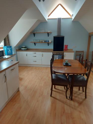 a kitchen and dining room with a table and chairs at Tower House in Crawfordsburn