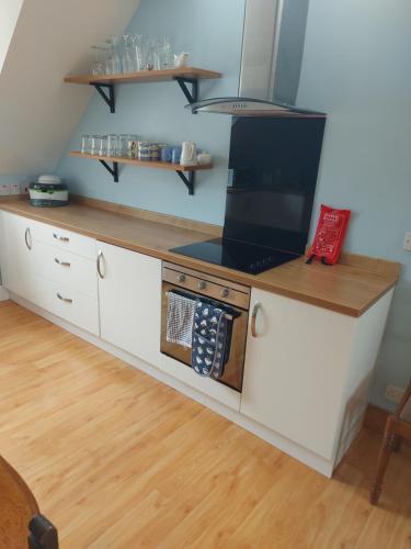 a kitchen with white cabinets and a stove at Tower House in Crawfordsburn