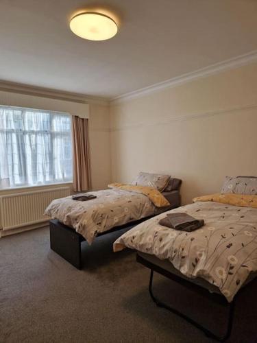 a bedroom with two beds and a window at Modern 3BD London Flat in London