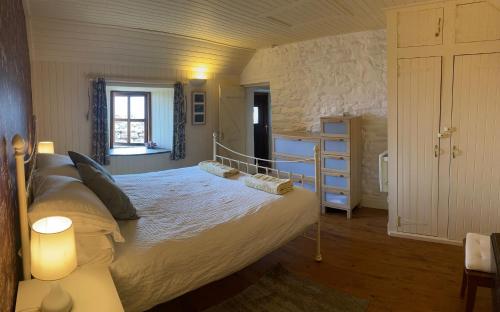a bedroom with a large bed and a window at The Ruah - Clifftop Retreat in Whitehall