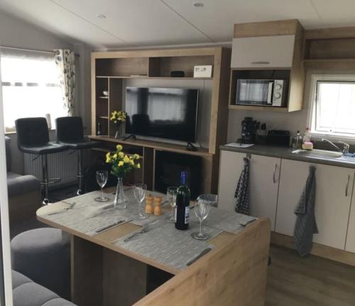 eine Küche mit einem Tisch und Weingläsern darauf in der Unterkunft Brookside West Sands Holiday Park Seal Bay Selsey in Selsey