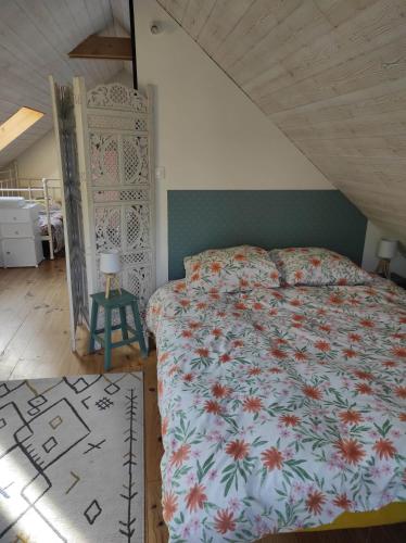 a bedroom with a bed with a floral bedspread at Chez Jess in Bazinghen