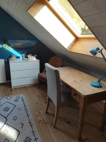 a dining room with a wooden table and a skylight at Chez Jess in Bazinghen