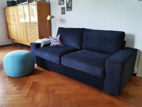 Sofá azul en la sala de estar con reposapiés azul en Gundis Gästezimmer en Bamberg