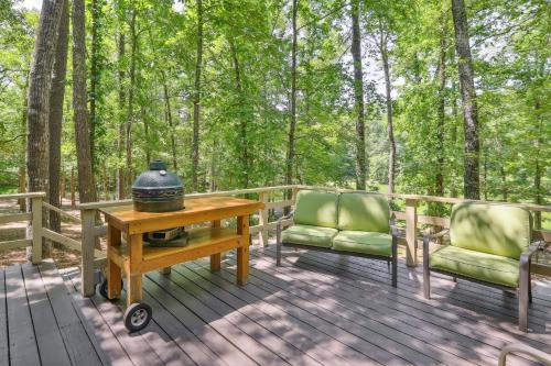a table and two chairs on a deck with trees at Lakefront Hamilton Cabin with Dock and Fire Pit! in Hamilton