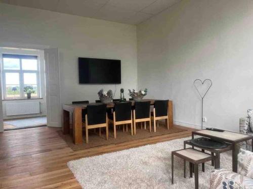 Lövestad的住宿－Skolan i Näsby lägenhet D，客厅配有桌子和墙上的电视