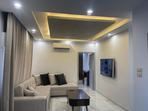 a living room with a couch and a table at Oqdeh Delux Apartments in Jerash