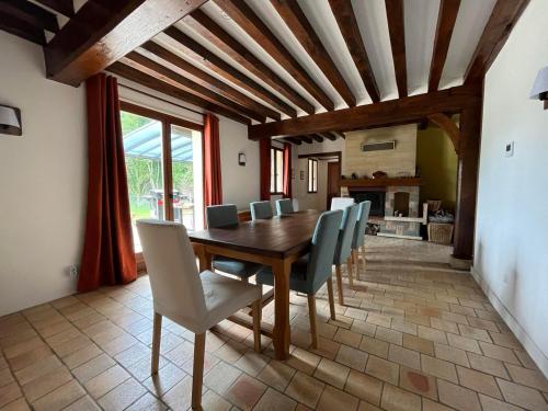 Un comedor con mesa y sillas de madera. en Le Verger en Auge, en Saint-Léger-sur-Bonneville