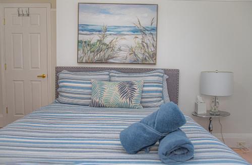 Cama con sábanas y almohadas de rayas azules y blancas en Your Cozy and Relaxing Retreat, en Woburn