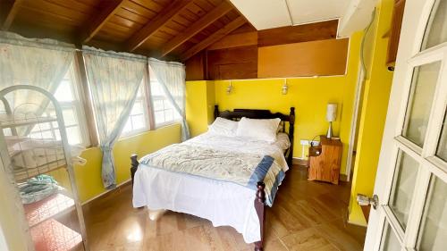 1 dormitorio con cama y pared amarilla en Coco Mango Suites en Portsmouth