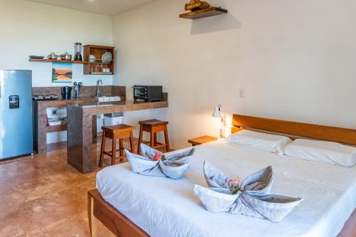 ein Schlafzimmer mit einem großen weißen Bett mit Kissen darauf in der Unterkunft Mot Mot Vacation in Sámara