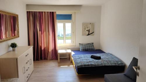 ein kleines Schlafzimmer mit einem Bett und einem Fenster in der Unterkunft City Home St Gallen in St. Gallen