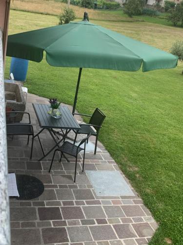 a table and chairs under an umbrella on a patio at Casa S. Caterina 