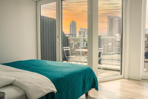 a bedroom with a large window with a view of a city at The Residence Enschede in Enschede