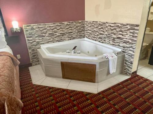 a bath tub with a sink in a room at Super 8 by Wyndham Paris IL in Paris