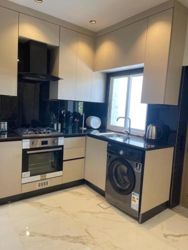 a kitchen with a washing machine and a stove at Oqdeh Delux Apartments in Jerash