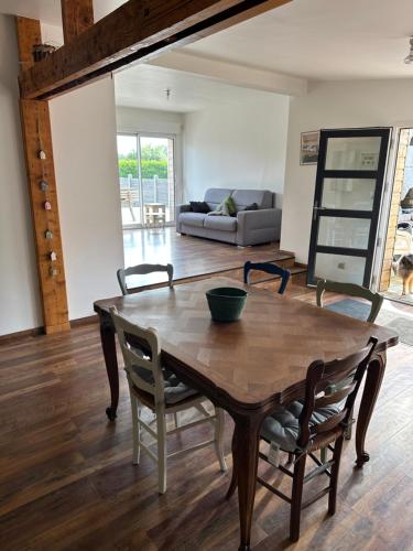 ein Wohnzimmer mit einem Holztisch und Stühlen in der Unterkunft Cottage entre Terre et Mer in Gouville-sur-Mer