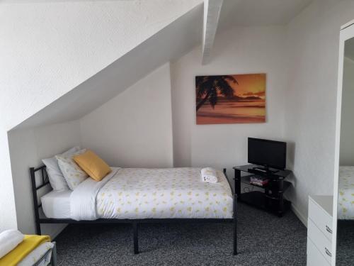 a small bedroom with a bed and a television at Your Home away from Home. in Headingley