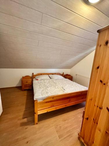 a bedroom with a wooden bed in a attic at Ferienhaus Seepark Kirchheim in Kirchheim