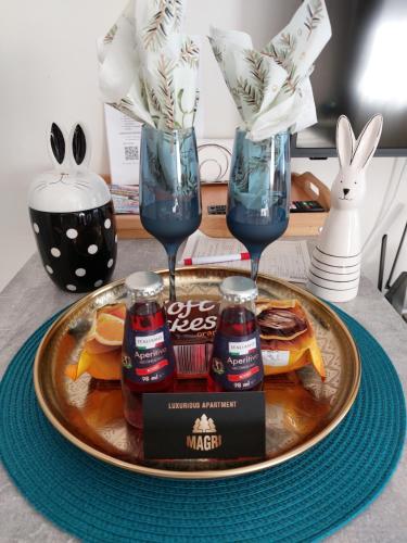 een bord met drankjes en twee glazen en een bord eten bij MAGRI Luxurious Apartment A42 Borovets Gardens in Borovets