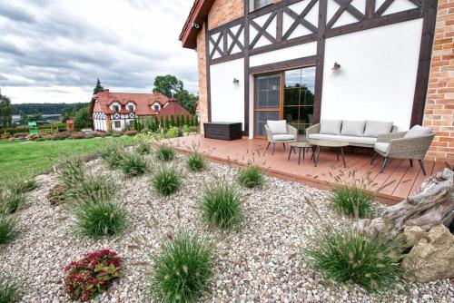 un patio con sofá y sillas en una terraza de madera en Uroczysko Lutówko, en Sępólno Krajeńskie