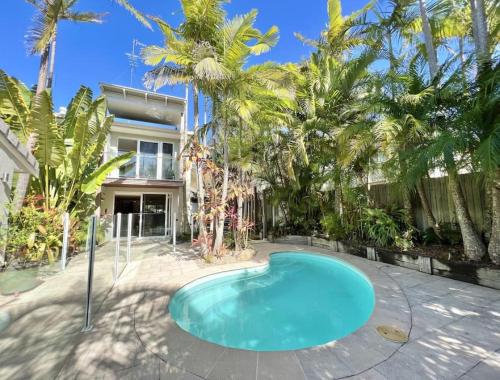a swimming pool in front of a house with palm trees at Sunshine Beach Oasis Private Pool Pet Friendly solway in Sunshine Beach