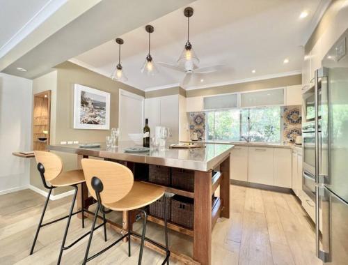 a kitchen with a large island with chairs and a counter at Sunshine Beach Oasis Private Pool Pet Friendly solway in Sunshine Beach