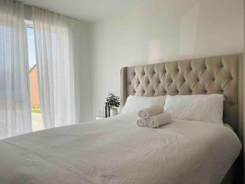 a bedroom with a large bed with two towels on it at Luxurious modern new built 4 bedrooms in Manchester