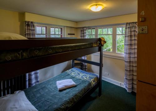 1 dormitorio con litera y ventana en HI Penticton - Hostel, en Penticton