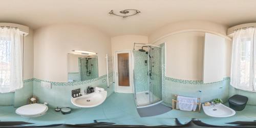 a bathroom with two sinks and a shower and two mirrors at Art Deco' - Sleepwithme - Free Parking - Free Breakfast - Very Friendly Staff in Pisa