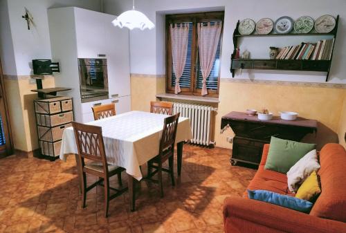 una sala da pranzo con tavolo, sedie e divano di B&B "Madama Granèt" a Borgo San Dalmazzo