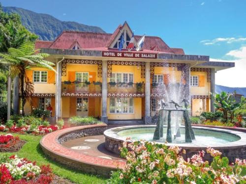 a building with a fountain in front of a building at The Secret Motel 5 Salazie à 15 min d'Hell bourg in Salazie