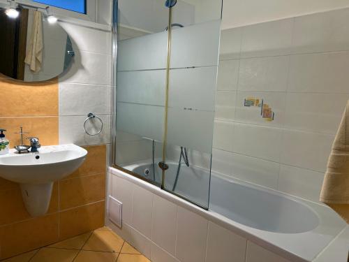 Un baño con ducha, lavabo y bañera. en Penzión TOKAJ MACIK WINERY Guesthouse, en Malá Tŕňa