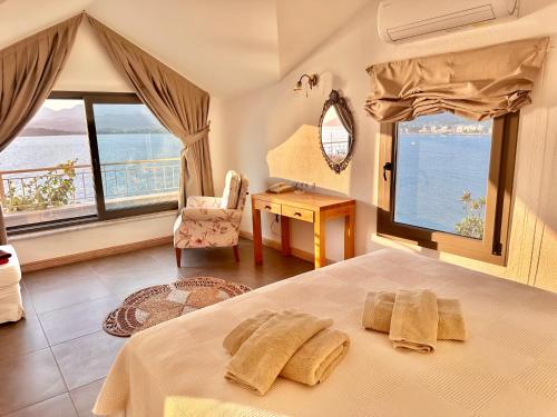 a bedroom with a bed and a desk and windows at Ece Hotel Sovalye Island in Fethiye