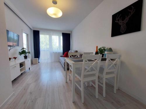 salon z białym stołem i krzesłami w obiekcie Albatros Apartment Stogi w Gdańsku