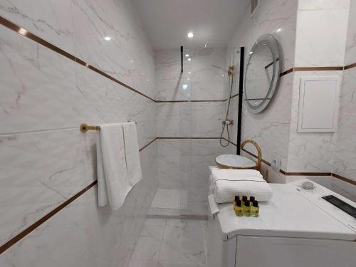 biała łazienka z prysznicem i umywalką w obiekcie Albatros Apartment Stogi w Gdańsku