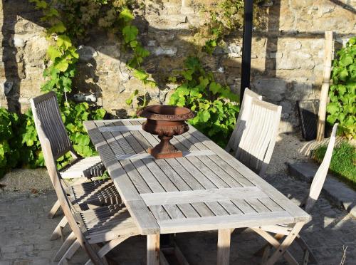 einem Holztisch mit zwei Stühlen und einer Schüssel darauf in der Unterkunft Bonjour Pierreuse in Lüttich