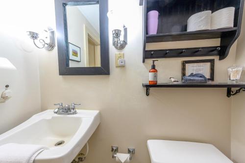 a bathroom with a sink and a toilet and a mirror at Brass Lantern Inn in Stowe