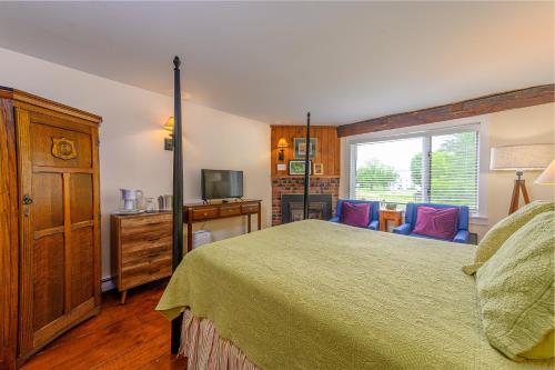 a bedroom with a large bed and a television at Brass Lantern Inn in Stowe