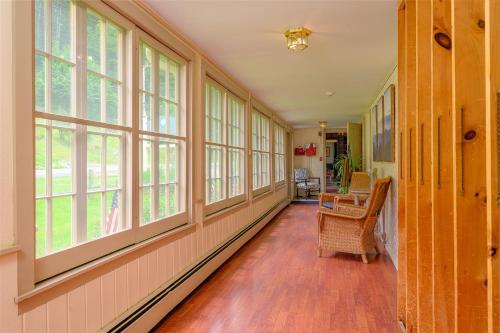 an empty hallway with windows and a wooden floor at Brass Lantern Inn in Stowe