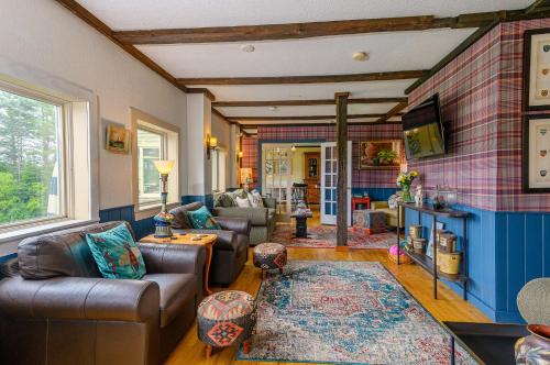 a living room with couches and a tv at Brass Lantern Inn in Stowe