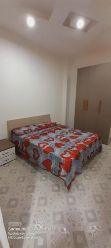 a bedroom with a bed with a red and blue blanket at Annarita House in Trinitapoli