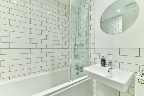 ein weißes Bad mit einem Waschbecken und einer Dusche in der Unterkunft Beautiful New House in Derby For up to 5 Guests, Suitable for Families Contractors NHS Staff etc in Derby