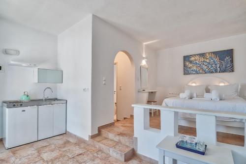 a white room with a bed and a sink at Palm Heaven Boutique Apartments in Antiparos