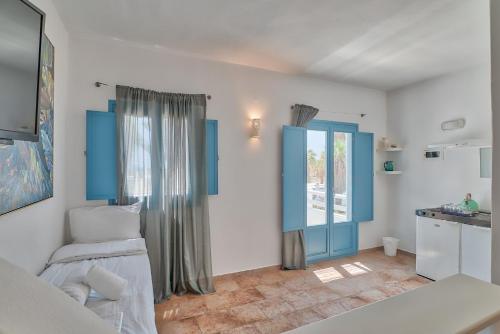 a bedroom with blue and white walls and a kitchen at Palm Heaven Boutique Apartments in Antiparos