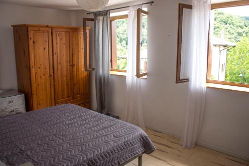 a bedroom with a bed and two windows at Casa Natura e Quiete in Stregna