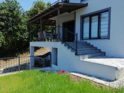 uma casa com uma escada e uma varanda em Kiralık Lüx Deniz Manzaralı Bahçeli Villa/Luxury Sea View Garden Villa for Rent em Trabzon