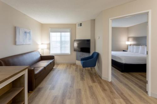 Habitación de hotel con cama y sofá en Grandstay Apple Valley, en Apple Valley
